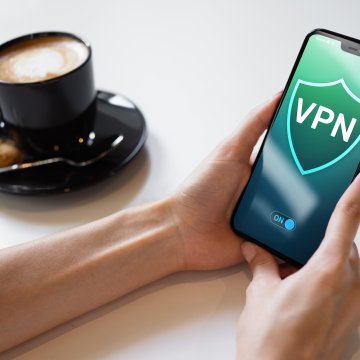 vpn on smartphone cup of coffee holding a smartphone vpn services